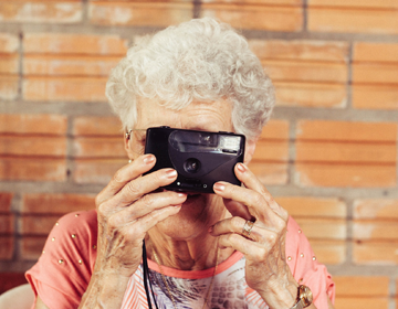 seniorka robi zdjęcia aparatem kompaktowym