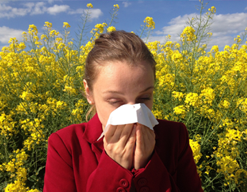 kobieta wyciera nos chusteczką z powodu kataru alergicznego