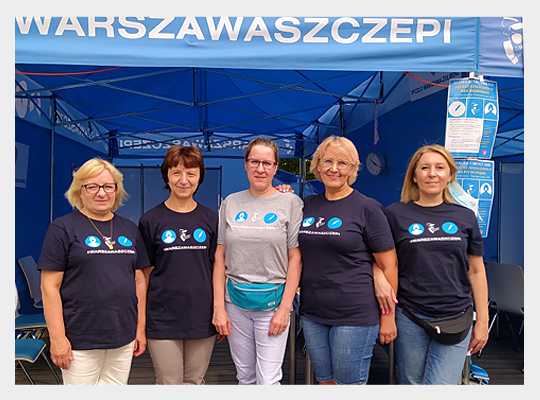 zespół pracowników SPZZLO Warszawa-Żoliborz na tle Warszawskiego Punktu Szczepień