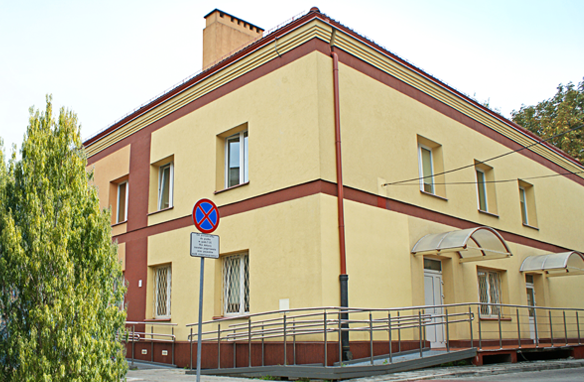 mały, żółty budynek przychodni przy ulicy Kleczewskiej 56 na warszawskich Bielanach wśród zieleni