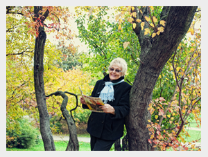 Szczęśliwa, starsza kobieta czata kwartalnik o zdrowiu w parku