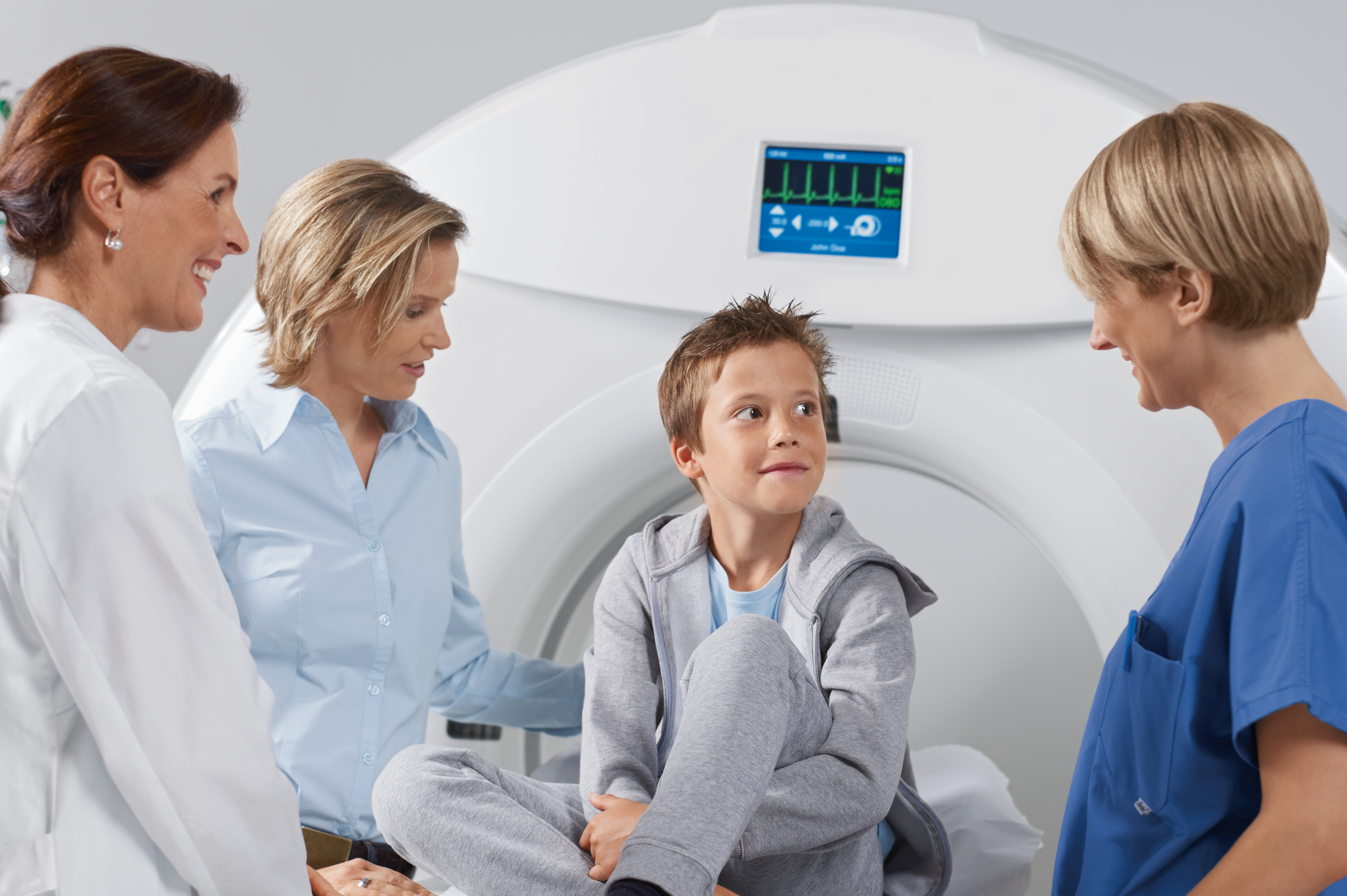 Chłopiec przed badaniem tomograficznym w otoczeniu mamy, lekarki oraz techniczki 
