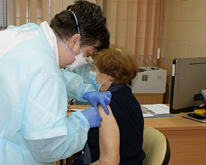 Pielęgniarka wykonuje szczepienie przeciw COVID-19
